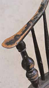 Arm of a painted Windsor chair.